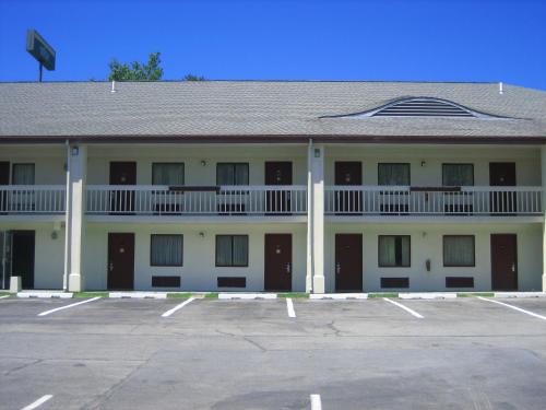 a large white building with a parking lot at Days Inn by Wyndham Queensbury/Lake George in Queensbury