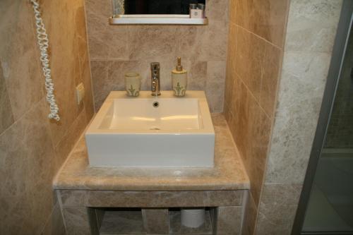 a bathroom with a white sink and a shower at Villanaz Apart Hotel in Bitez