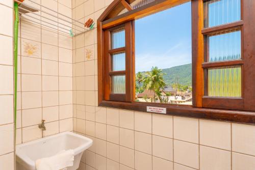 a bathroom with a bath tub and a window at Chalés Four Seasons in Ubatuba