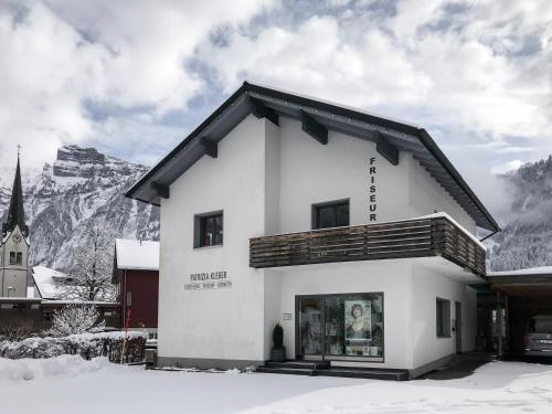 a white building with a mountain in the background at Am Mellenbach Patrizia Kleber in Mellau