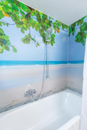 a bath tub with a view of the beach mural at Am Mellenbach Patrizia Kleber in Mellau