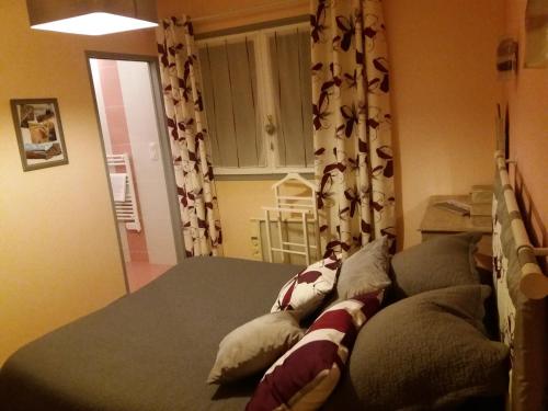 une chambre avec un lit avec des oreillers dessus dans l'établissement Mer et campagne, à Ploemeur