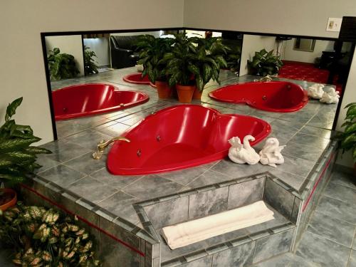 ein Badezimmer mit drei roten Badewannen auf der Theke in der Unterkunft Patuxent Inn in La Plata