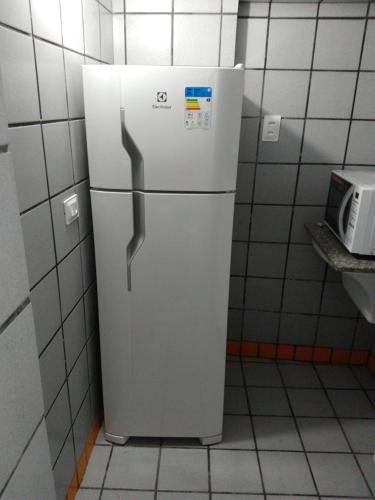 a white refrigerator in a kitchen with a microwave at Edf. Iracema Costa in Recife