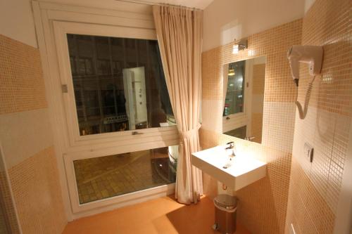 a bathroom with a window and a sink and a mirror at Hotel La Madonnina in Milan