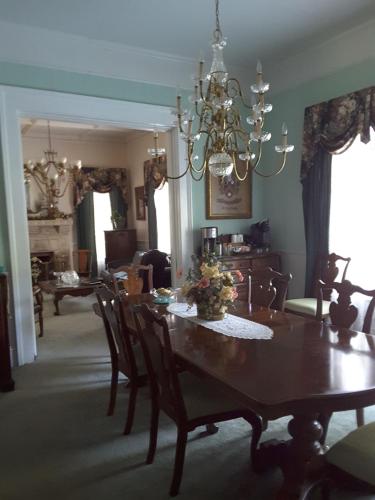 a dining room with a table and chairs and a chandelier at Strickland Arms Bed and Breakfast in Austin