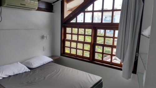 ボンビーニャスにあるApartamentos Morada Aquitâniaのベッドと大きな窓のある寝室