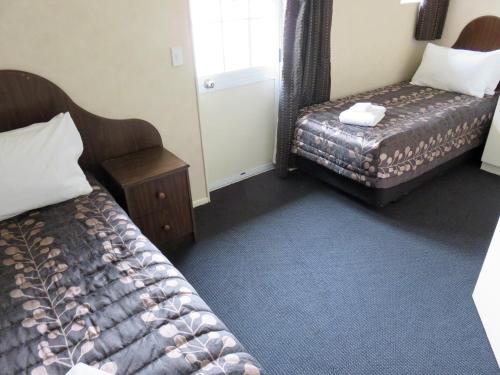 a hotel room with two beds and a window at Admirals Motor Lodge in Blenheim
