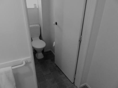 a bathroom with a toilet and a white door at Admirals Motor Lodge in Blenheim
