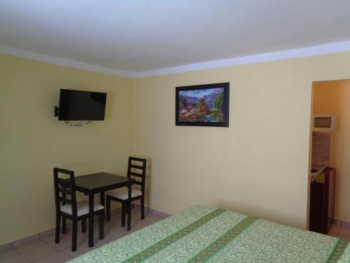 a room with a bed and a table and a tv at Hotel Panama 510 in Tampico