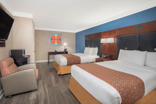 a hotel room with two beds and a chair at Budget Inn & Suite Atlanta Marietta Stadium in Marietta