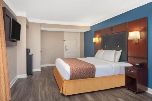 a hotel room with a bed and a flat screen tv at Budget Inn & Suite Atlanta Marietta Stadium in Marietta