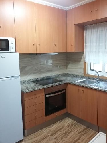 una cucina con armadi in legno e frigorifero bianco di Al Gaia Centro Historico a Vila Nova de Gaia
