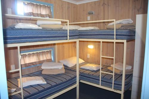 a room with four bunk beds in a boat at Lani's Holiday Island in Forster