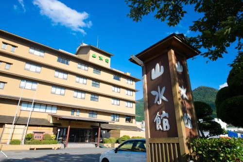 a hotel with a sign in front of a building at Yufuin Sansuikan in Yufu