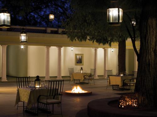 a group of tables and chairs with a fire in a courtyard at Sawai Madhopur Lodge - IHCL SeleQtions in Sawāi Mādhopur
