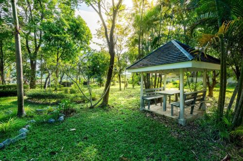 a gazebo with a picnic table and a bench at Ivy Cottage by Qiu in Sara Buri