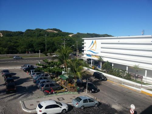 um parque de estacionamento com carros estacionados em frente a um edifício em CP Hotel Economic em Natal