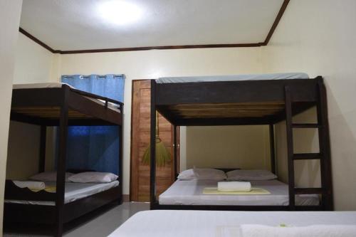 two bunk beds sitting in a room with at Bia's Beach House, Pagudpud in Pagudpud