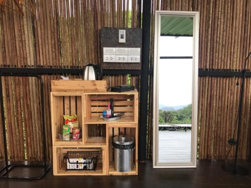 a room with a door and a shelf and a mirror at Tanoshi Glamping In Khao Sok in Khao Sok