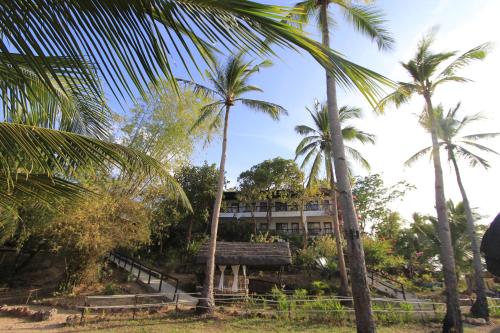 a building with palm trees in front of it at Discovery Island Resort in Coron