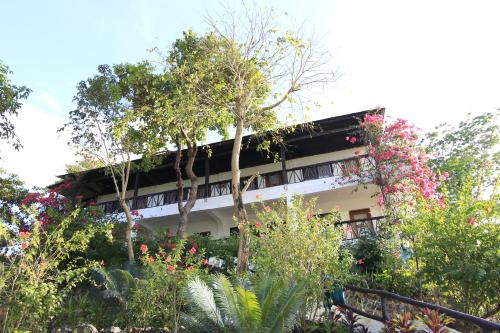 a building with trees and flowers in front of it at Discovery Island Resort in Coron