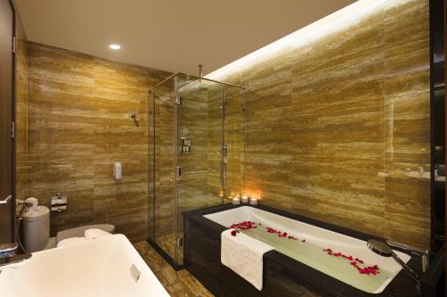 a bathroom with a tub and a toilet and a shower at Emerald Bay Hotel & Spa Nha Trang in Nha Trang