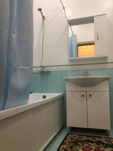 a bathroom with a sink and a tub and a mirror at TRILLIONER Apartment 885 in Aktau
