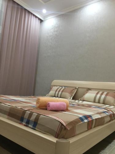 uma cama com duas almofadas num quarto em TRILLIONER Apartment 885 em Aktau