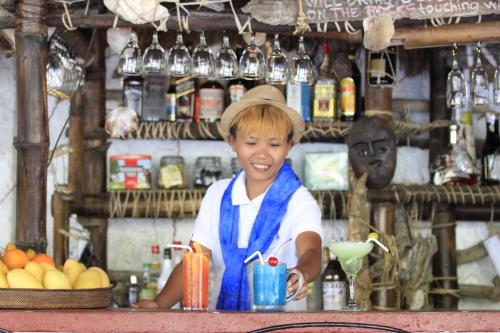 a young boy is standing behind a counter with a drink at Discovery Island Resort in Coron