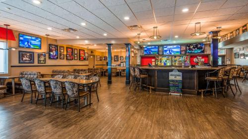 a restaurant with tables and chairs and a bar at Seven Oaks Hotel Regina in Regina