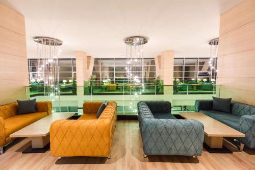 a waiting room with couches and tables and windows at Best Western Premier Batumi in Batumi