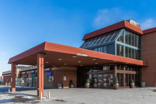 un grand bâtiment en briques avec un toit rouge dans l'établissement Seven Oaks Hotel Regina, à Regina