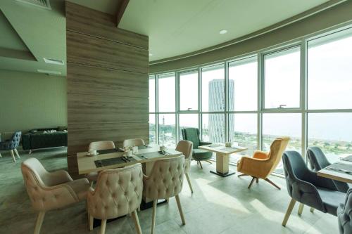 a waiting room with chairs and tables and windows at Best Western Premier Batumi in Batumi
