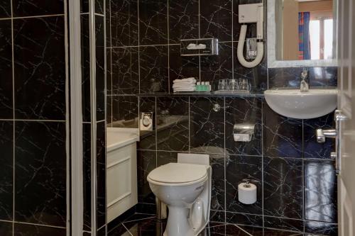 
a bathroom with a toilet, sink, and shower at The Bull Hotel; Sure Hotel Collection by Best Western in Peterborough
