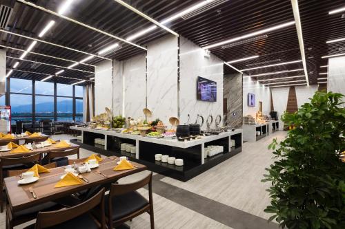 a restaurant with tables and chairs in a room at Emerald Bay Hotel & Spa Nha Trang in Nha Trang