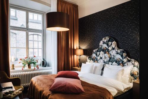 a bedroom with a large bed and a window at NOFO Hotel, WorldHotels Crafted in Stockholm