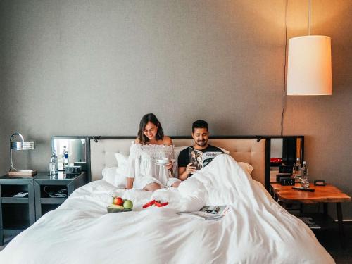 a man and a woman laying in bed at Grand Hyatt Berlin in Berlin