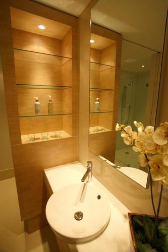 a bathroom with a white sink and a mirror at Grand Mercure Allegra Hervey Bay in Hervey Bay