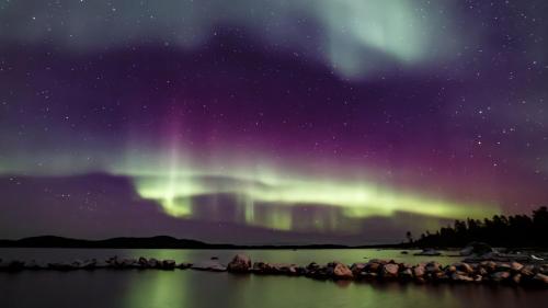 an aurora in the sky over a body of water at Chalet Suomukka in Suomutunturi