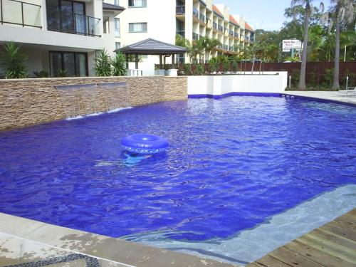 a blue pool with a frisbee in the water at Grand Mercure Allegra Hervey Bay in Hervey Bay
