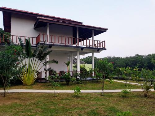 a house with a balcony on the side of it at Pearl Cave Cabanas & Resturant in Tangalle