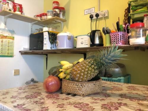 Woodpecker Lodge, Kuching في كوتشينغ: سلة من الفواكه تجلس على طاولة في مطبخ