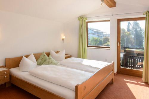 ein Schlafzimmer mit einem Bett und einem großen Fenster in der Unterkunft Gästehaus Schmid in Oberstaufen