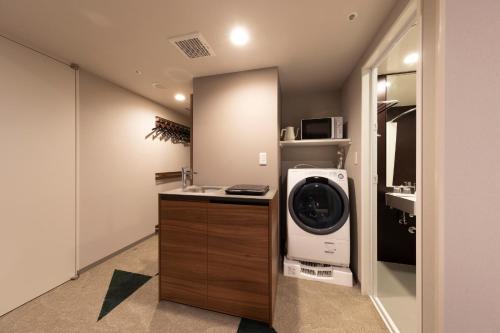 a bathroom with a washing machine and a sink at Tokyu Stay Sapporo Odori in Sapporo
