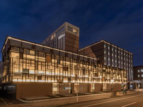 a building with lights on in front of a street at Hakodate Kokusai Hotel in Hakodate