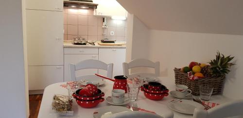 a kitchen with a table with red cups and plates at Apartments Vijolica in Kranjska Gora