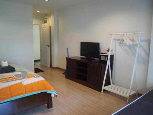 a bedroom with a bed and a tv in it at Nong Nuey Rooms in Ko Samed