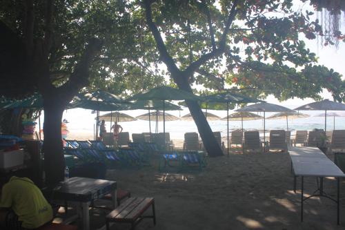 a group of chairs and tables and umbrellas on a beach at Nong Nuey Rooms in Ko Samed