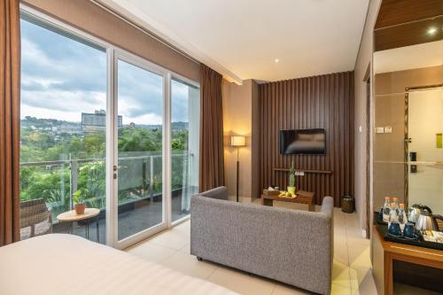 una habitación de hotel con una cama y una ventana grande en Clove Hotel Bandung, en Bandung